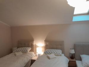 2 Einzelbetten in einem Zimmer mit Fenster in der Unterkunft Angel sky in Drniš
