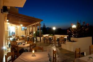 a restaurant with tables and chairs at night at Albatross Hotel in Maleme