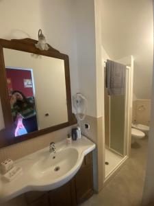 a bathroom with a sink and a mirror and a toilet at Bed&Wine in Brisighella