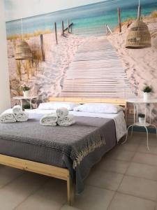 una camera con letto e passerella per la spiaggia di CASA IDA residence Girasole a Torre dell'Orso