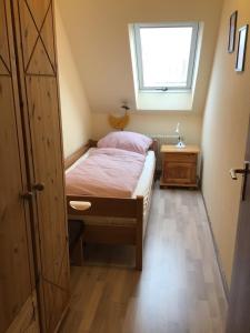 a small bedroom with a bed and a window at Haus Strandgang, Whg 5 in Kellenhusen