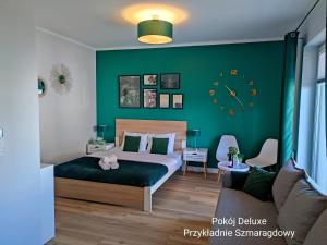 a bedroom with a bed and a green wall at BALTICUS Mrzeżyno in Mrzeżyno