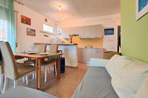 uma sala de estar com uma mesa e uma cozinha em Le Dune Sea View Apartments - Futura CAV em San Vincenzo