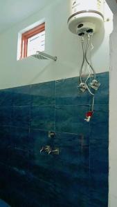 La salle de bains est pourvue d'un lavabo et d'une lumière sur le mur. dans l'établissement Hotel Holy Spirit, à Phata