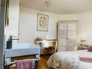 a bathroom with a sink and a bed at Maébrilu Camargue Provence in Salin-de-Giraud