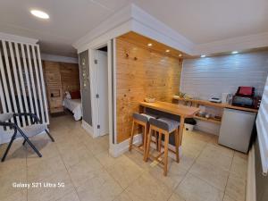 a kitchen with a wooden wall with a table and chairs at Loft Altos Suite in Puerto Natales