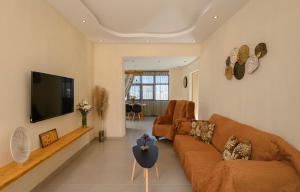 salon z kanapą i telewizorem z płaskim ekranem w obiekcie Auster House Santorini w mieście Kamari