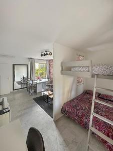 a bedroom with a bunk bed and a dining room at Magniolias - Résidence Calme avec Piscine, Tennis & Jardin in Antibes