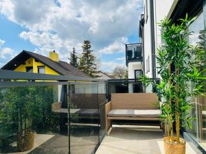 einen Glasbalkon mit einer Bank und einigen Pflanzen in der Unterkunft New - Free Parking - Balcony in Wien