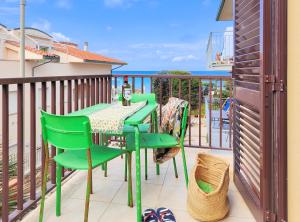 a green table and chairs on a balcony with the ocean at Le Dune Sea View Apartments - Futura CAV in San Vincenzo