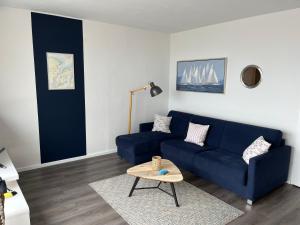 a living room with a blue couch and a table at Ferienwohnung Fördedeck in Kiel +11 photos