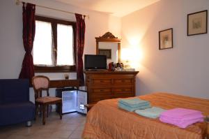 Schlafzimmer mit einem Bett, einem Schreibtisch und einem TV in der Unterkunft B&B Belvedere in SantʼAntìoco