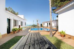 a wooden bench in the backyard of a house with a swimming pool at Novobarrosa D in Chiclana de la Frontera