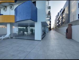 ein leerer Innenhof eines Gebäudes mit Tischen und Stühlen in der Unterkunft Apartamento Pé Na Areia - Praia do Bessa - PB in João Pessoa