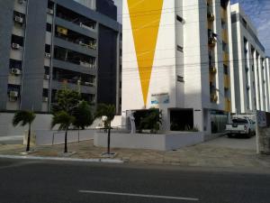 un edificio con una franja amarilla en el costado en Apartamento Pé Na Areia - Praia do Bessa - PB en João Pessoa