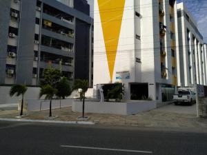 ein Gebäude mit einem gelben Streifen auf der Seite in der Unterkunft Apartamento Pé Na Areia - Praia do Bessa - PB in João Pessoa