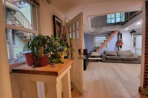 a living room filled with plants and a staircase at Harvard Squares ONLY Tiny House on the Charles! in Cambridge
