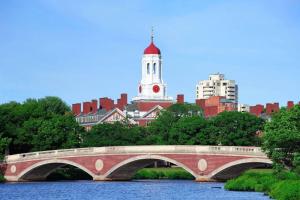 a bridge over a river in front of a building at Harvard Squares ONLY Tiny House on the Charles! in Cambridge