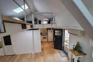 an attic room with white cabinets and a kitchen at Harvard Squares ONLY Tiny House on the Charles! in Cambridge