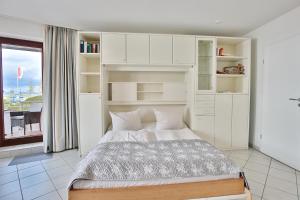 een witte slaapkamer met een bed en een raam bij Strandburg Strandburg Appartement 1 in Scharbeutz