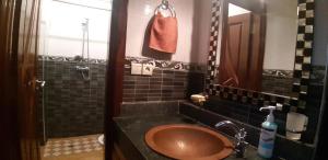 a bathroom with a brown sink and a mirror at Mubaradise Surf Hostel in Imsouane