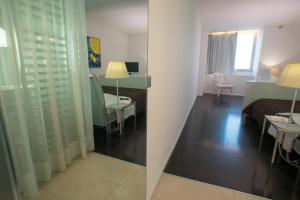 Habitación con cama y sala de estar con espejo. en Hotel iDesign en San Marino