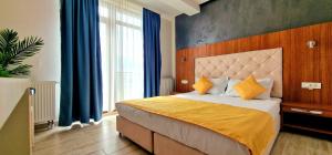 a bedroom with a large bed with blue curtains at Summer Love in Mangalia