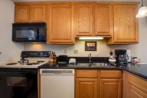 a kitchen with wooden cabinets and a stove and a sink at Beaver Village Unit #0221 in Winter Park