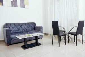 a living room with a couch and a glass table at L'IMMEUBLE QUEEN M.N.M in Douala