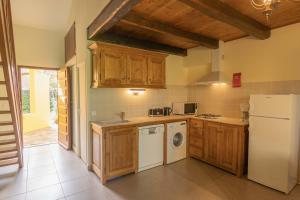 a kitchen with wooden cabinets and a white refrigerator at Residence Mare e Sole in Taglio-Isolaccio