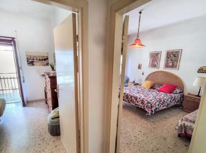 een slaapkamer met een bed en een deur naar een kamer bij Ampio Trilocale 6 posti San Beach in San Benedetto del Tronto