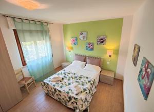 una camera con un letto in una stanza con pareti verdi di Le Dune Sea View Apartments - Futura CAV a San Vincenzo