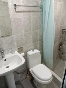 a bathroom with a white toilet and a sink at Grig in Yerevan