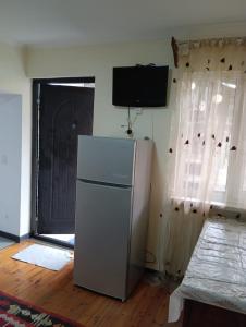 een witte koelkast in een kamer met een deur bij Grig in Jerevan