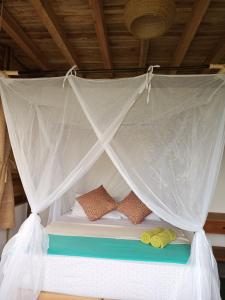 a bed with a mosquito net on top of it at Frana Lodge in El Zaino