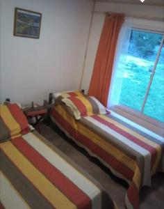 Dos camas sentadas en una habitación con ventana. en La Rosadita, en Necochea