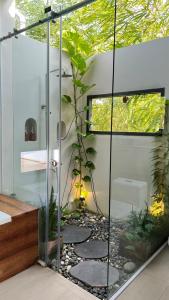a bathroom with a shower with a glass door at InnerZen Riverside homestay Ben Tre - Japanese style in Ấp Phú Hòa (3)