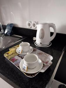 a kitchen counter with two cups and plates and a coffee pot at Benalmadena Palace Spa in Benalmádena