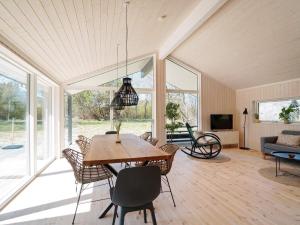 a living room with a wooden table and chairs at Holiday home Hundested XI in Hundested