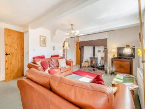 a living room with a leather couch and a tv at Hollow Creek Cottage - 28012 in Rockcliffe