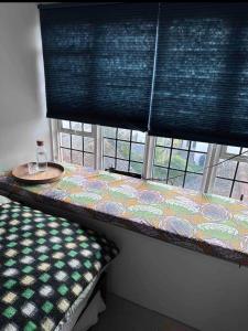 a room with a bed and a table in a window at Converted church in Beckenham