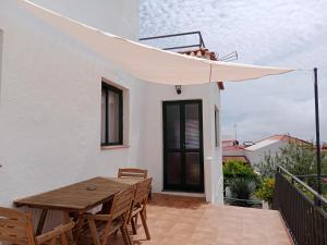 - une table et des chaises en bois sur un balcon avec un parasol dans l'établissement La Palma Hostel by Pension Central, à Fuencaliente de la Palma