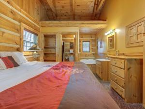 una camera con un grande letto in una baita di tronchi di Life's Escape, 2 Bedrooms, WiFi, Fireplace, Arcade, Jetted Tub, Sleeps 6 a Gatlinburg