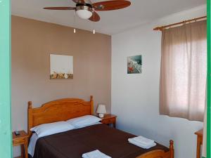 sypialnia z łóżkiem i wentylatorem sufitowym w obiekcie La Palma Hostel by Pension Central w mieście Fuencaliente de la Palma