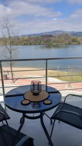 a table on a balcony with a view of a lake at Lago d'argento sobe in Veliko Gradište