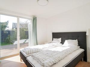 a large bed in a room with a large window at 6 person holiday home in Hornbæk-By Traum in Hornbæk +54 photos