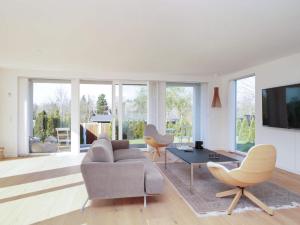 a living room with a couch and a table and chairs at 6 person holiday home in Hornbæk-By Traum in Hornbæk