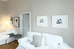 una sala de estar blanca con 2 sofás blancos en Schloss Hohenzollern - Wohnung 14, en Ahlbeck