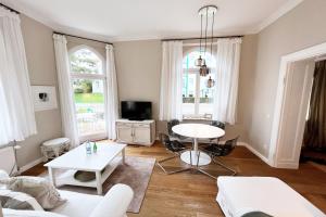 sala de estar con sofá blanco y mesa en Schloss Hohenzollern - Wohnung 14, en Ahlbeck