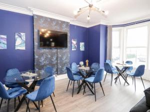 a dining room with blue chairs and tables at 23 Deganwy Avenue in Llandudno